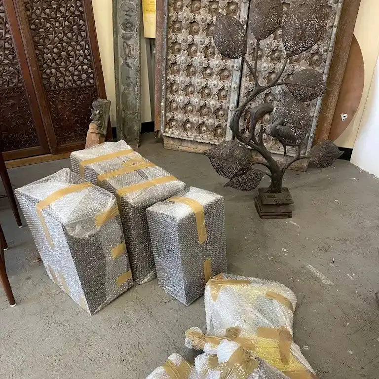 Wrapped items set down on a floor beside carved screens